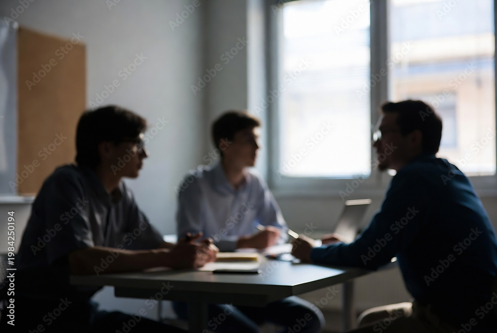 Fototapeta premium Three men are seated at a table, engaged in a discussion. It appears to be an office meeting.