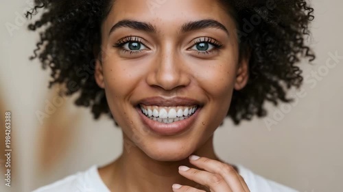 Young black woman smiling and touching her face indoors  