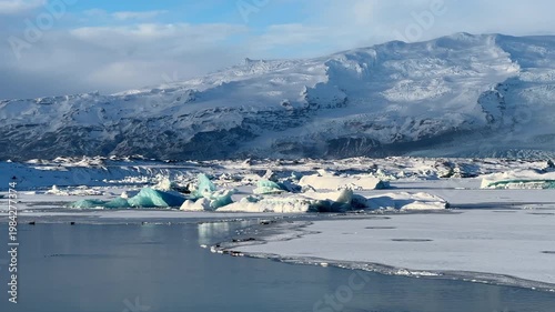 Luminous icebergs drifting on Jökullsarlon glacier lake in southern Iceland