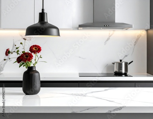 Modern kitchen black pendant lamp, red flowers in vase, white marble countertop, stainless hood