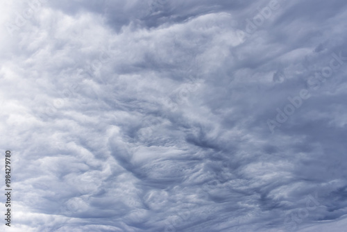 Heavy grey layered rain clouds stretch across the sky moments before the first raindrops fall