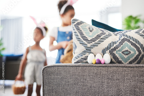 Fényképezés Easter, hunt and eggs on sofa in home, hidden and search with sisters together in living room