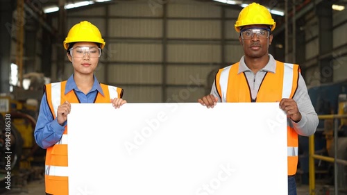 Construction Workers Holding Blank Sign in Industrial Setting