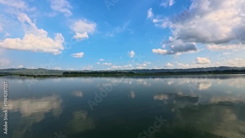 Aerial view of Sutami Dam at sunset with golden reflections on the reservoir water