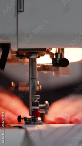 Close-up footage of hands sewing blue fabric with a machine. The steady rhythm of the needle and the meticulous guidance of the fabric reflect the skill and care behind every stitch.