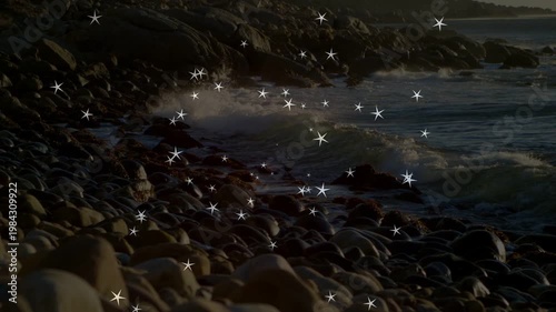 Incoming swell causing star sparkles over rocky shore, waves rolling, crashing, accenting spray