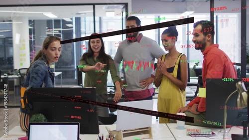 Seated woman manipulating mouse, updating overlaid stock charts while team pointing and approving