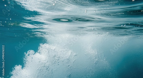 Underwater view of bubbles and water surface with turquoise and white tones. Sunlight filters through creating a serene aquatic scene. Perfect for ocean, swimming, diving, and water-related projects.