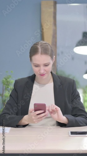 Wallpaper Mural Businesswoman Browsing Internet on Smartphone in Office, Vertical Video Torontodigital.ca