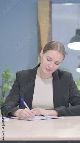 Wallpaper Mural Businesswoman Writing while Sitting in Office, Vertical Video Torontodigital.ca
