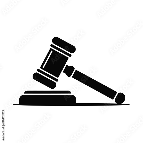 A black gavel rests on a sound block in a courtroom setting