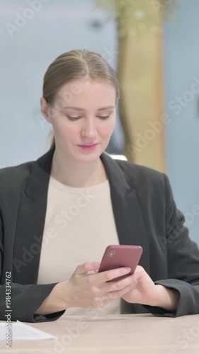 Wallpaper Mural Businesswoman Browsing Internet on Smartphone in Office, Vertical Video Torontodigital.ca