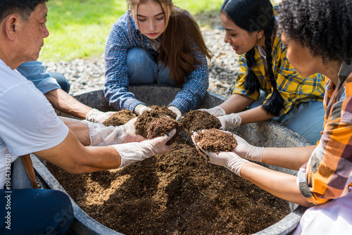 A group of people of various nationalities are mixing soil for cultivation.