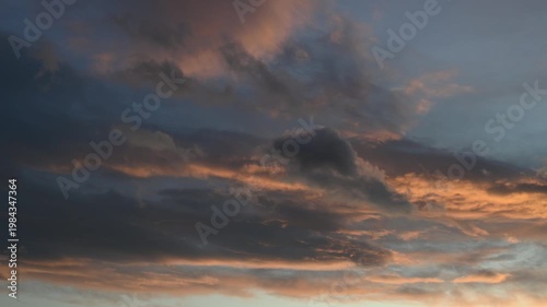 Dramatic sunset clouds with hues of orange and blue in the sky.
