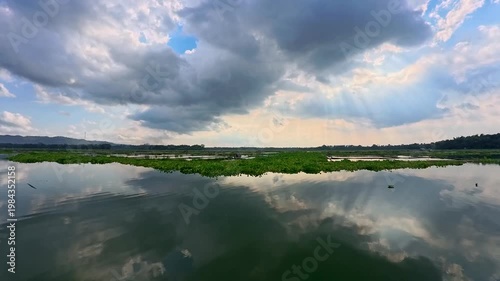 Aerial view of Sutami Dam at sunset with golden reflections on the reservoir water