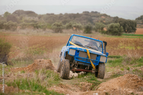 Blue off-road vehicle navigating challenging dirt terrain