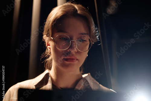 Close up of Caucasian young adult woman performing standup on stage, reading script with focused expression. Useful for comedy promotion, live event marketing, entertainment branding
