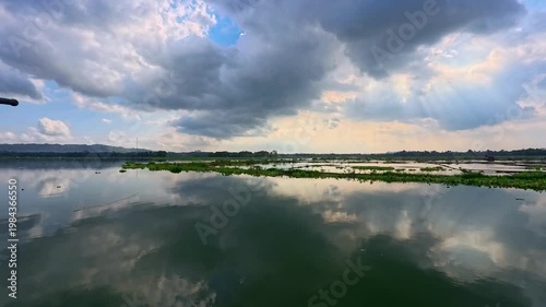 Aerial view of Sutami Dam at sunset with golden reflections on the reservoir water