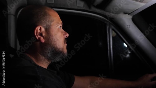 Delivery driver drives a van at night with full concentration. The scene shows responsibility, focus, and professional driving in low light.