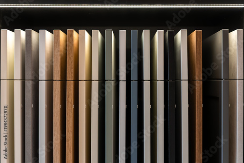 Kitchen cabinet samples on shelf with reflective display. Modern interior design material selection.