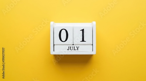 Wooden calendar with july 1 date on yellow background top view.