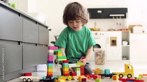 Young boy playing with colorful building blocks on the floor at home, focused on creative play and learning.