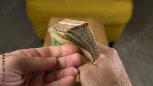 Close-up of Hands Counting a Stack of US Dollar Banknotes on Table
