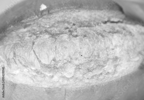 Black and white close up of bread crust texture. Monochromatic shot of artisanal bread. Close up on the details of the bread in black and white.