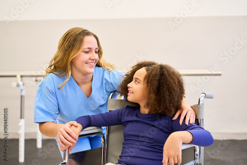 Therapist and child in wheelchair, pediatric physiotherapy session, rehabilitation exercises, motor skills training, physical therapy, rehab center, happy and smiling