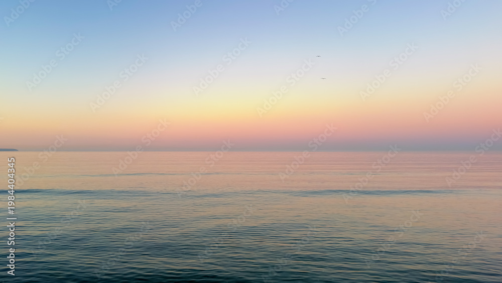Obraz premium Minimalist sea sunset landscape with gradient sky. Calm water surface under pastel horizon.