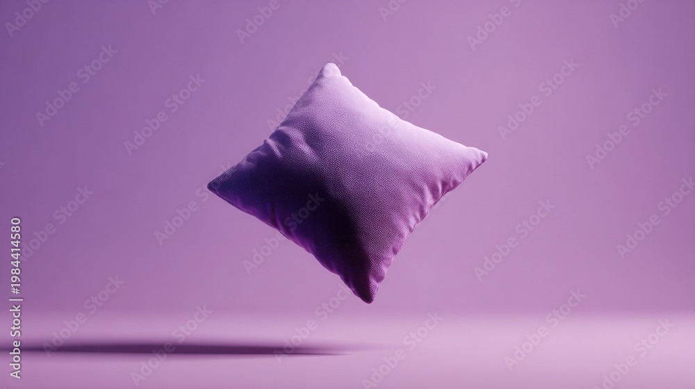 Fototapeta premium Purple decorative pillow floating in mid-air against a matching purple studio background