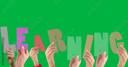Multiple hands holding learning text banner against black background