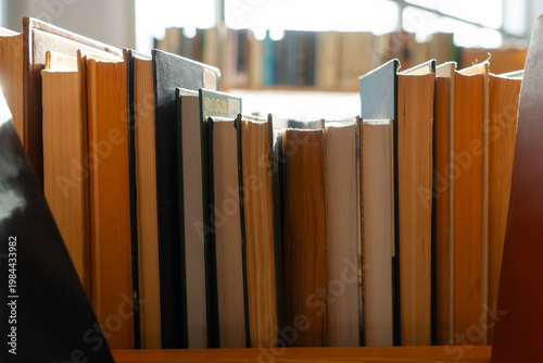 Φωτογραφία Old books on the bookshelf in library archive interior in sunny day