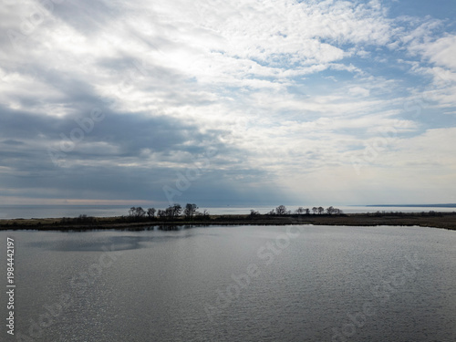 Still Lake Water Reflecting Cloudy Sky Over Island Trees in Demirkoy