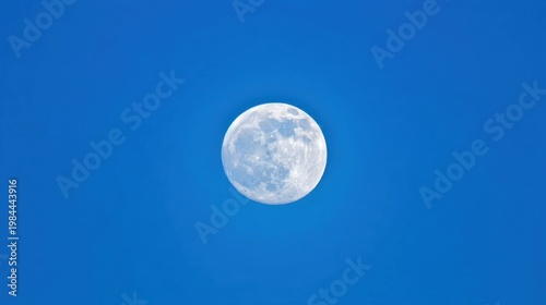 A bright full moon with visible craters and maria hangs in a pure blue sky, creating a serene and surreal scene.