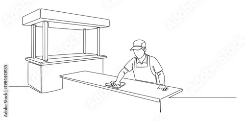 Worker in a cap and apron diligently wiping down a food stall counter providing a clean and sanitary environment for food service or preparation