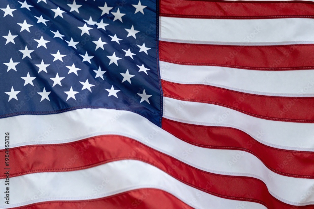 Obraz premium An american flag is waving in the wind. 