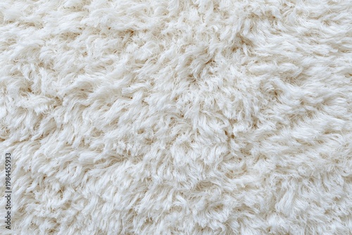 High angle close-up view of a soft, fluffy, textured, white rug or carpet surface