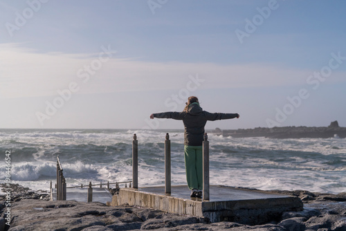 Person Standing by the Sea with Arms Open Ireland Travel Freedom