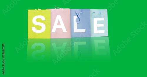 Digital animation of sale text over multiple colorful shopping bags against black background