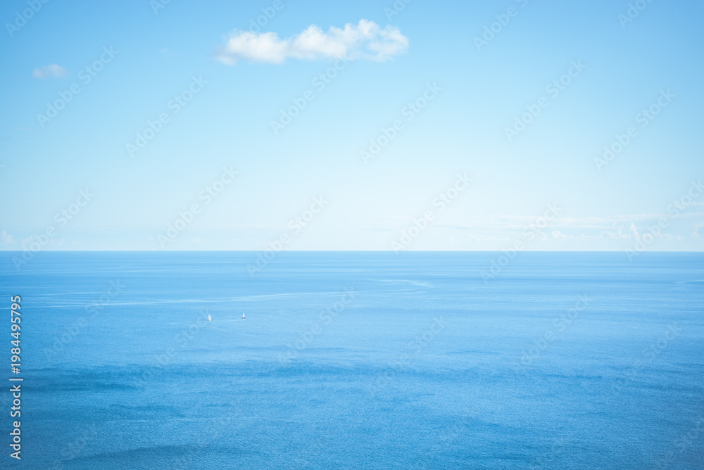 Fototapeta premium Tyrrhenian Sea, Italy: Two sailboats on a calm blue ocean under a clear sky