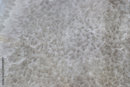 Smooth, cut surface of a milky quartz geode, texture background