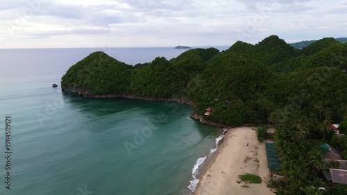 aerial drone shot of the golden sands and turquoise waters of Sugar Beach, tucked between lush green hills in Sipalay, Negros Island Philippines travel holiday destination