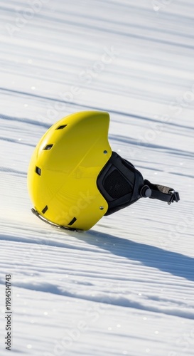 Yellow Ski Helmet Resting on Snowy Slope.
