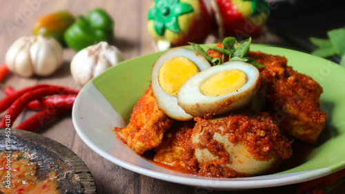фотографія Bali telur, a classic Indonesian side dish of hard-boiled eggs and tofu in a rich spicy sauce, is often enjoyed with steamed white rice
