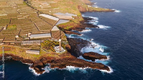 Aerial View of La Fajana Lighthouse and Coastal Banana Plantations at Sunrise; Maritime Infrastructure, Industrial Agriculture, and Solar Azimuth, La Palma, Canary Islands, Spain