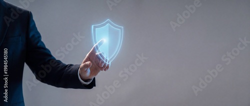 Businessman Interacting with Digital Shield Symbol for Cybersecurity and Data Protection Concepts