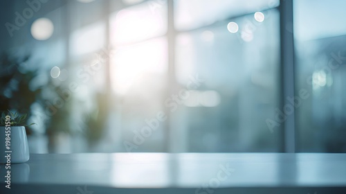Minimalist Office Space: A serene, blurred interior of an office or workspace, capturing natural light streaming through expansive windows, hinting at a calming atmosphere.