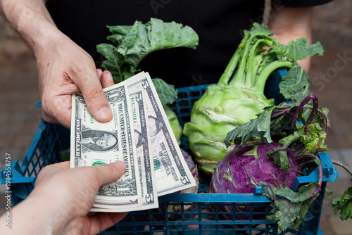 buyer of fresh vegetables pays merchant in cash dollars