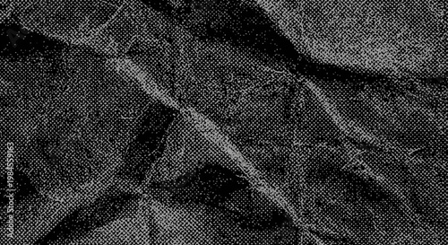 A close-up view of a dark crumpled paper texture with deep folds